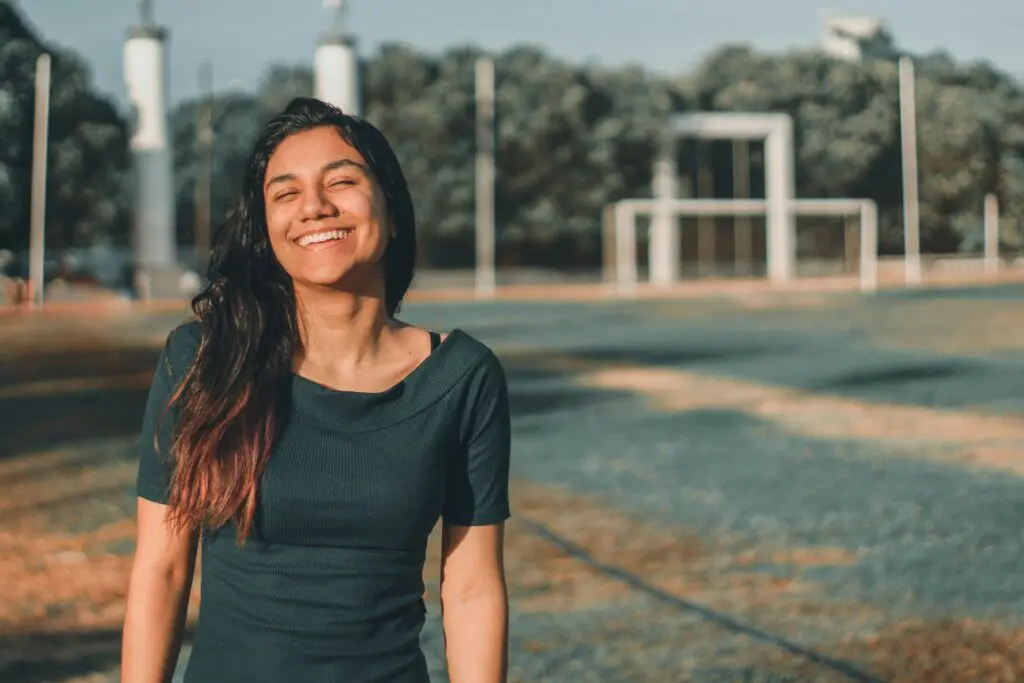 high school or college woman smiling on athletic field